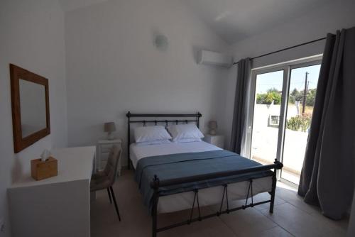 a bedroom with a bed and a large window at Sofia Villa Near Faliraki in Kalithies