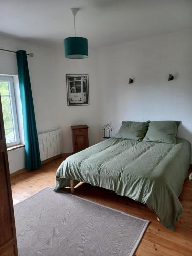 une chambre avec un lit avec une couette verte dans l'établissement les chambres du Kergolo, à Plouézec