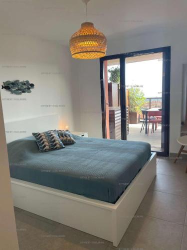 - une chambre avec un lit dans un dortoir doté d'une terrasse dans l'établissement 4TERIMP-A02 T3 neuf avec terrasse climatisation parking Collioure, à Collioure