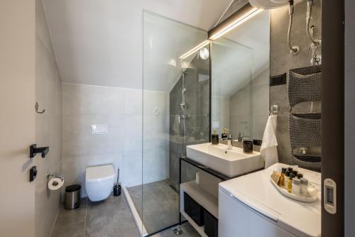 a bathroom with a sink and a toilet and a mirror at Golden Sunset Sutivan - Exclusive 4-Star Apartment in Sutivan