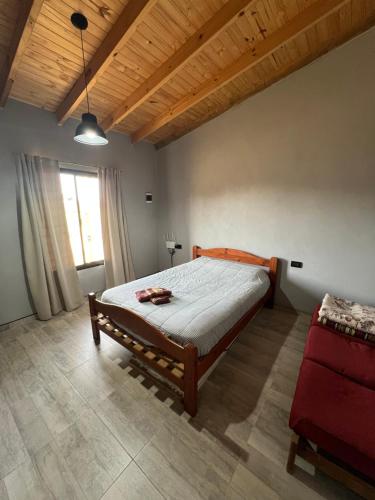 a bedroom with a large bed and a red couch at El Cardo in General Belgrano