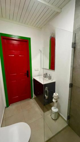 a bathroom with a red door and a sink at Carnaby Butik Otel Küçükköy in Ayvalık