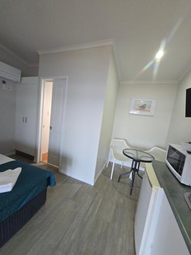 a small room with a bed and a table at Absolute Oceanfront Tourist Park in Bargara