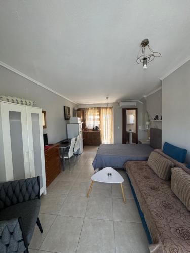 a living room with a couch and a bed at Roses Apartments in Néa Michanióna