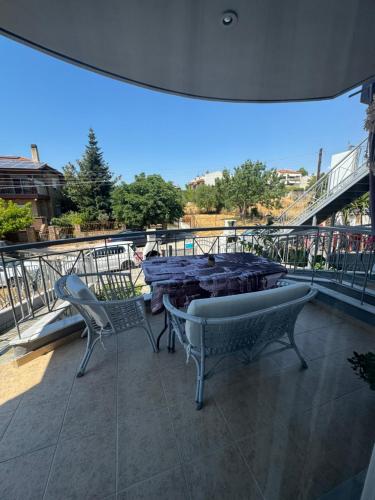 a patio with a table and chairs on a balcony at Roses Apartments in Néa Michanióna