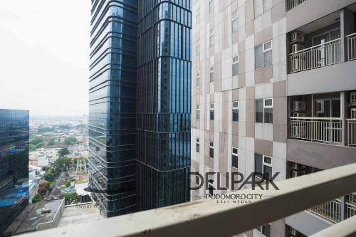 a view of a tall building with a sign on it at Delipark Mall 2 Bedrooms 2 Bathrooms 4-6 Pax Lexington Tower Level 11 in Medan