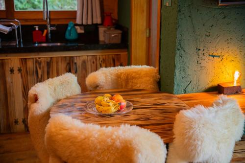 a table with two chairs with a bowl of fruit on it at Cascata dos Amores in Urubici