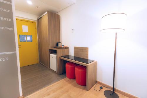a room with a desk and a lamp in a room at TRYP By Wyndham Ribeirão Preto in Ribeirão Preto