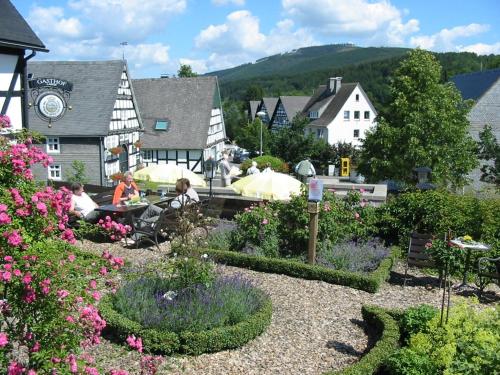 a group of people sitting at a table in a garden at Gasthof Kettler in Assinghausen