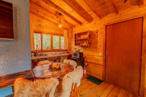 a dining room with a wooden table and chairs at Cascata dos Amores in Urubici