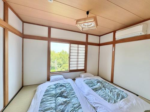a bed in a room with a window at 海の小石 in Ito