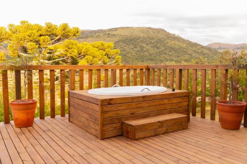 a hot tub sitting on a wooden deck with two pots at Cascata dos Amores in Urubici