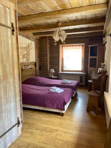 ラ・ブレスにあるAuberge des Skieursのベッドルーム1室(紫のシーツが敷かれたベッド1台、窓付)