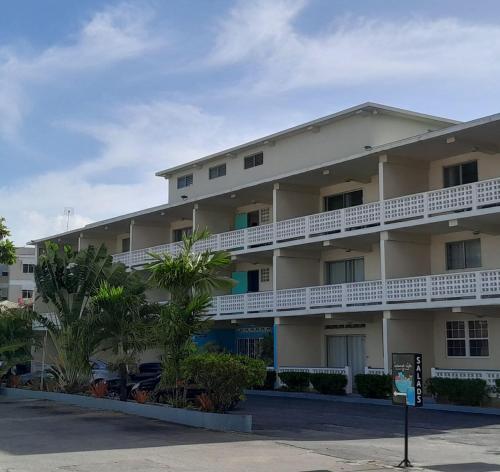 un condominio con balconi bianchi e palme di Melrose Beach Apartments Inc a Bridgetown