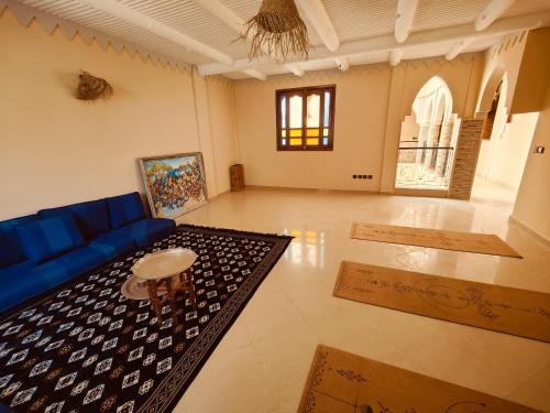 a living room with a blue couch and a table at Riad Noor in Agadir