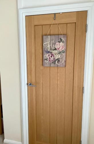a wooden door with a sign on it at Lorton Villa with a Log Burner in Saint Helens