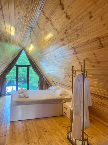 a bedroom with a bed in a wooden ceiling at RIVERSIDE Cottage in Martvili