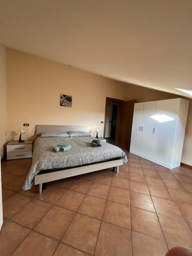 a bedroom with a bed and a tiled floor at Appartamento Mansarda nel verde in Tavullia