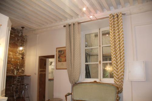 リヨンにあるラ　スイート　プレスキルの椅子と窓が備わる客室です。