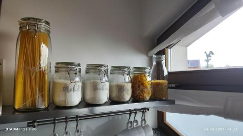 a row of jars filled with food on a shelf in a kitchen at Ferienwohnung Wiesmühlstrasse in Henndorf am Wallersee