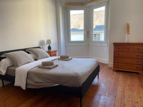 une chambre avec un grand lit avec deux serviettes dessus dans l'établissement Cocon Appartement Hyper-centre proche plage et marché - 2 chambres, au Pouliguen