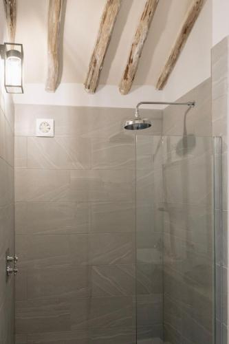 a glass shower in a bathroom with exposed ceilings at 1 Henham Barns in Beccles