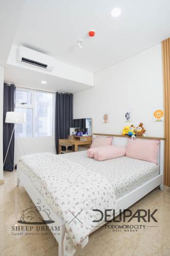 a bedroom with a bed with pink pillows at SheepDream 18DS DeliparkMall 2Bedroom, 1Bathroom in Medan