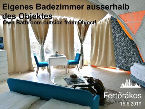 a living room with a couch and a table and chairs at Tinyhouses am Neusiedlersee in Fertőrákos