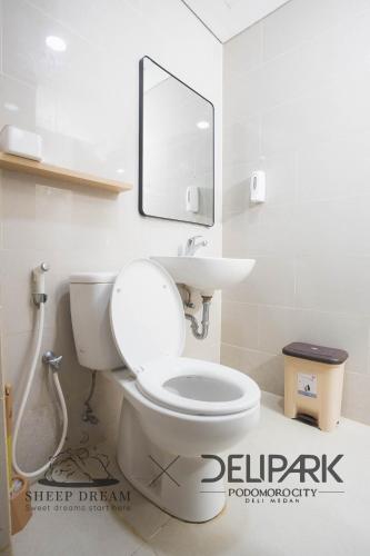 a bathroom with a white toilet and a mirror at SheepDream 18DS DeliparkMall 2Bedroom, 1Bathroom in Medan
