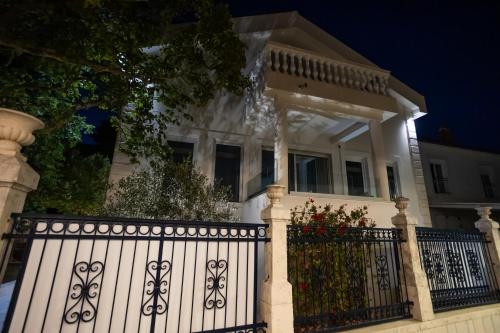 a white fence in front of a house at night at Villa Regens 1928 in Meljine