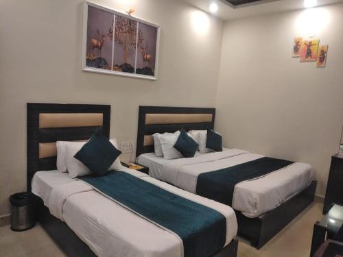 a hotel room with two beds in a room at Hotel Gopal in Haridwār