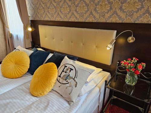 a bedroom with a bed with yellow pillows at Hotel Galicja SPA Wieliczka in Wieliczka