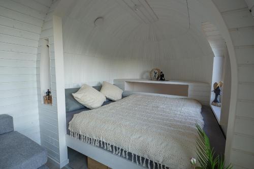 a bedroom with a bed in a white room at Glamping Skrytín in Dobkovice