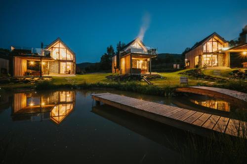 a house by the water at night with its lights on at Yama Krywe in Krywe