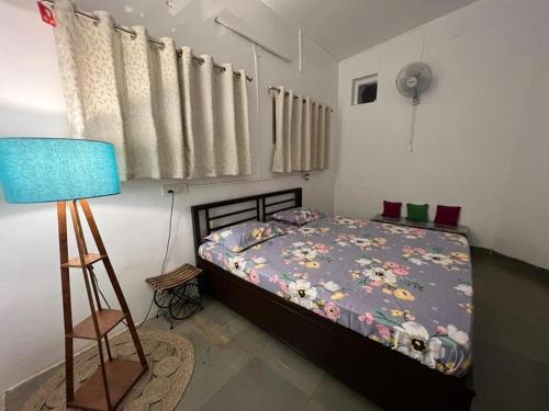 a bedroom with a bed and a blue lamp at Shalgar Villa The Homestay in Satara