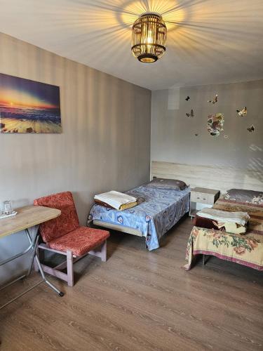 a room with two beds and a table and a chair at casa la meduza in Vama Veche