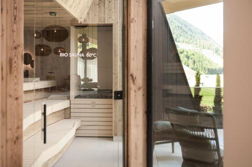 a room with a table and a chair and a window at Neueröffnung ELVA PREMIUM APARTMENT HOTEL inklusive Sommerpass STUBAI SUPER CARD in Neustift im Stubaital