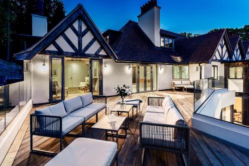 a patio with couches and tables on a wooden deck at Kingsley House in Haslemere