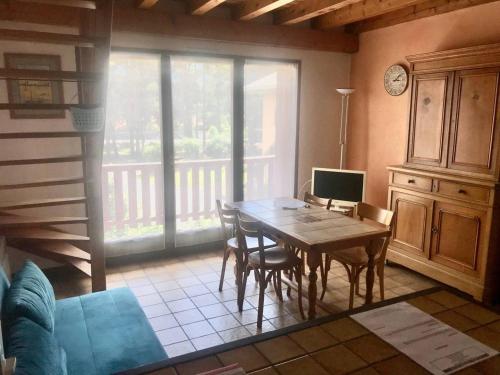 une salle à manger avec une table sur laquelle est posé un ordinateur dans l'établissement Duplex 3 pièces avec balcon, proche Barcelonnette - FR-1-804-35, à Saint-Pons