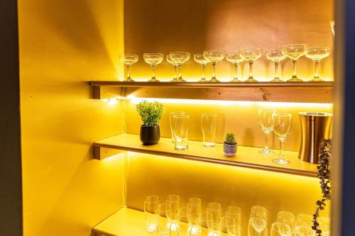 a bunch of wine glasses on shelves in a room at The Rockfield by Serene Stays Stylish 6BR near Anfield with Bar Virgin Media and Fast WiFi in Liverpool