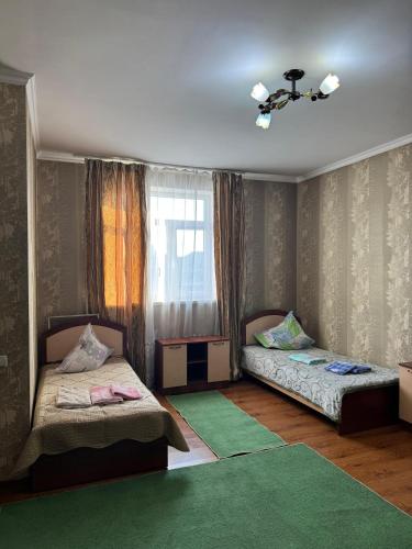 a bedroom with two beds and a window at Гостиница Асем-Ай in Taraz