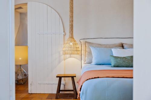 une chambre avec un lit, une table et une lampe dans l'établissement La Maison sur la plage - Les pieds dans l'eau, à Bonifacio