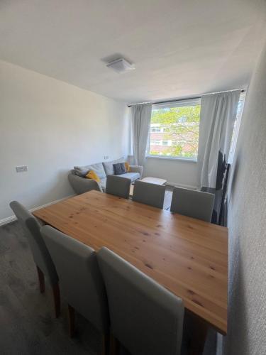 a dining room with a wooden table and chairs at Nilly apartment Richmond Close Birmingham b20 in Birmingham