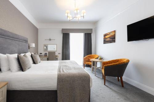 a hotel room with a bed and a desk and a tv at Best Western Hotel de Havelet in St Peter Port