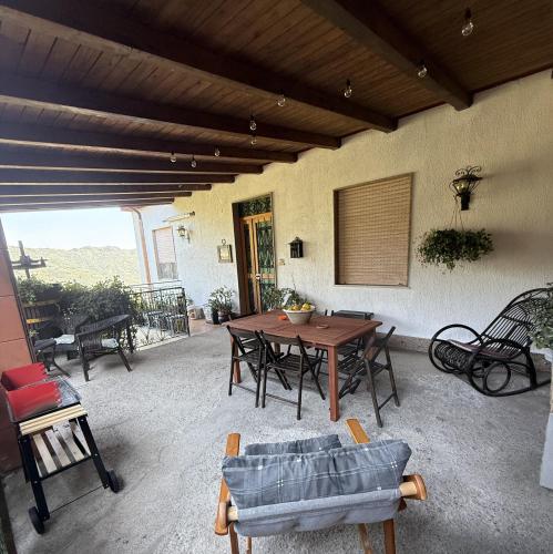 a patio with a wooden table and chairs at Villa Maria - Sant'Angelo di Brolo in SantʼAngelo di Brolo