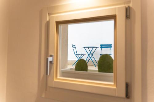 a window with a view of a table and chairs at Domus Juvenilia in Noto