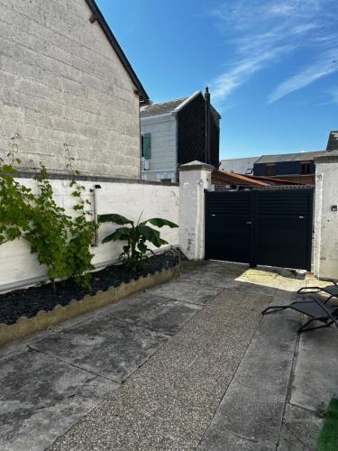 a house with a fence and a black gate at La Perle in Mers-les-Bains
