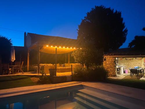 a backyard with a swimming pool at night at L'hébergerie sablotine in Chaillé-les-Marais