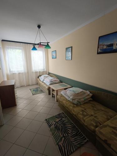 a living room with two beds and a couch at Apartament I in Rowy