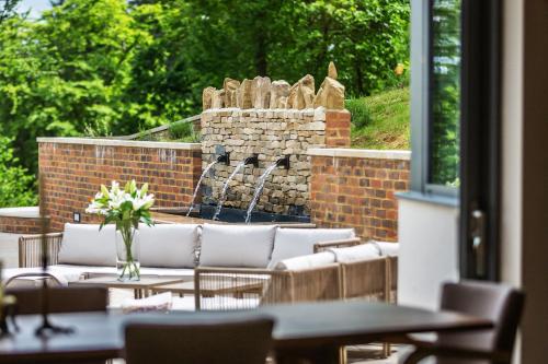 a patio with tables and chairs and a fountain at Kingsley House in Haslemere
